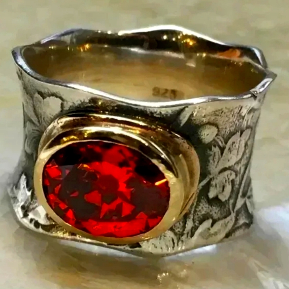 Imitation red moonstone set in a gold toned base on a silver toned band. Size 8.